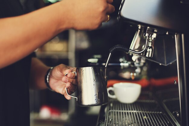 Persona trabajando con una máquina de cafe