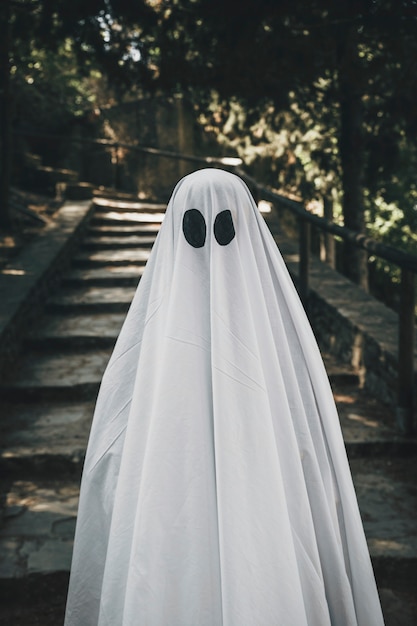 Foto gratuita persona en traje de fantasma de pie en el bosque