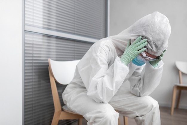 Persona en traje de protección con dolor de cabeza