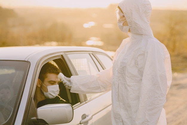 Persona en traje de protección verifica la temperatura