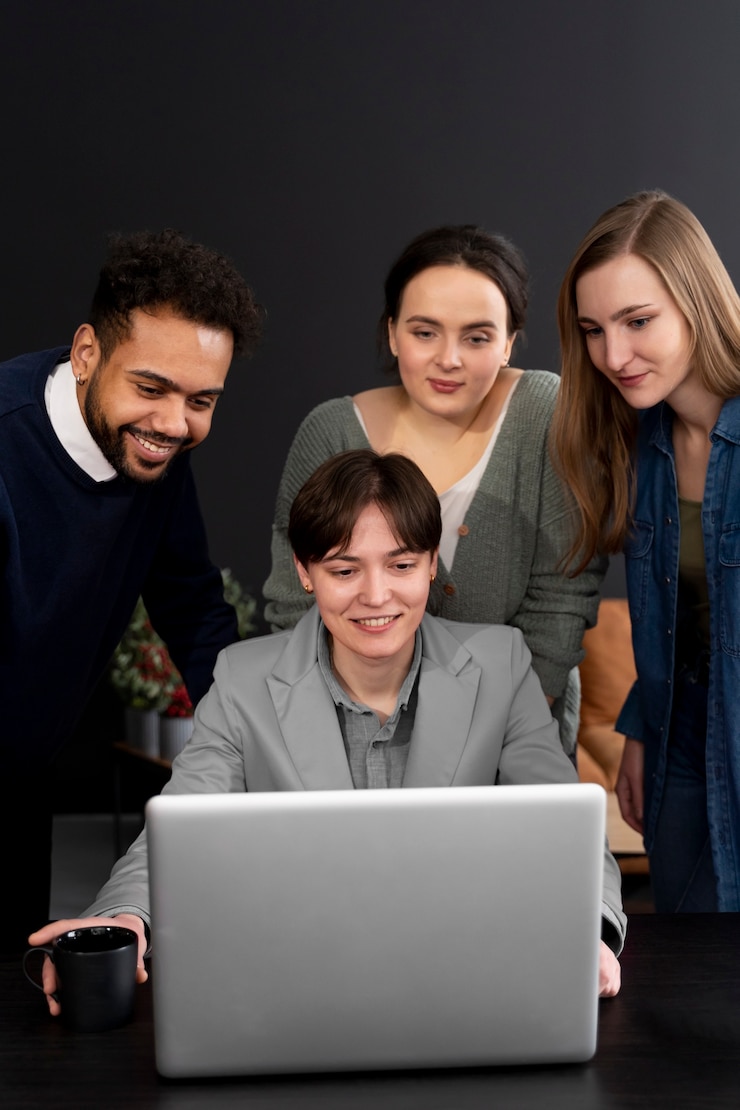 Foto gratuito persona trans que trabaja en la oficina con colegas