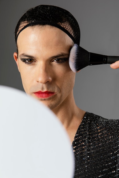 Persona transgénero joven mirando en el espejo