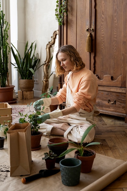 Persona trasplantando plantas en macetas nuevas