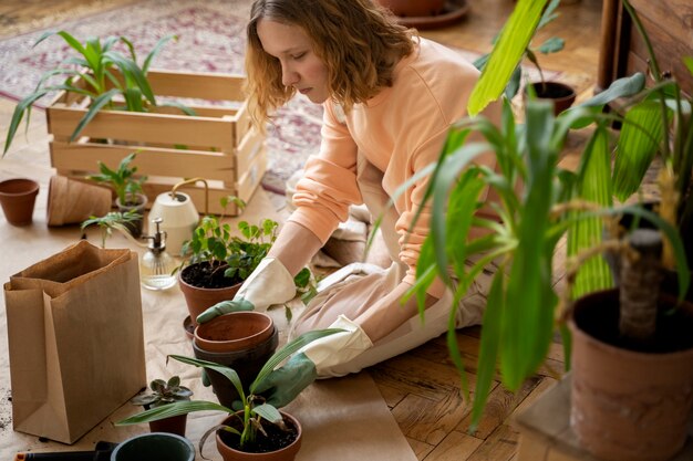 Persona trasplantando plantas en macetas nuevas