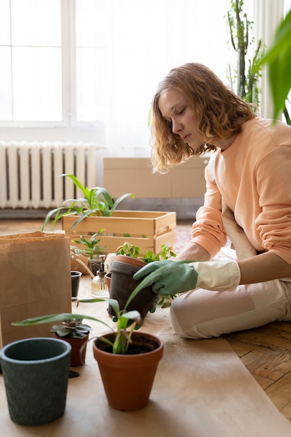 Foto gratuita persona trasplantando plantas en macetas nuevas