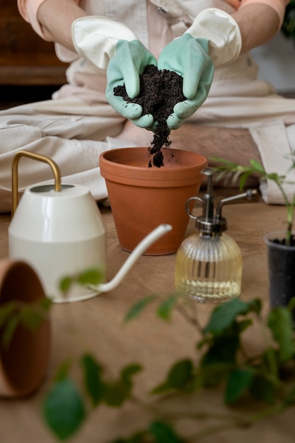 Foto gratuita persona trasplantando plantas en macetas nuevas