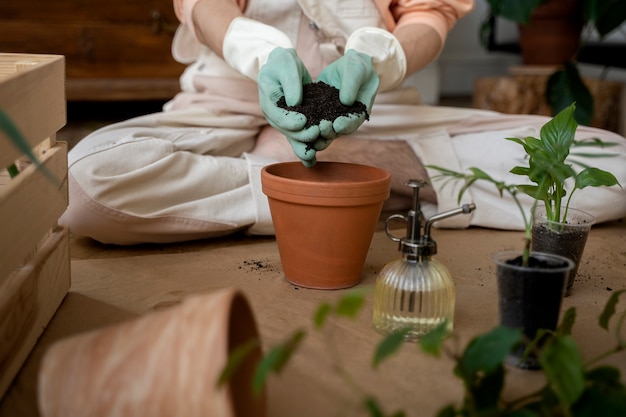 Persona trasplantando plantas en macetas nuevas