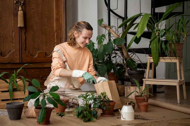 Persona trasplantando plantas en macetas nuevas