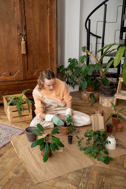 Persona trasplantando plantas en macetas nuevas