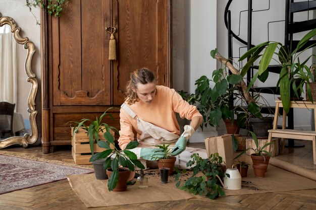 Persona trasplantando plantas en macetas nuevas