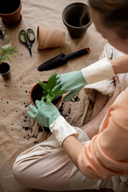 Persona trasplantando plantas en macetas nuevas