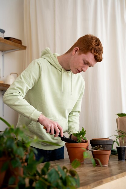 Persona trasplantando plantas en macetas nuevas