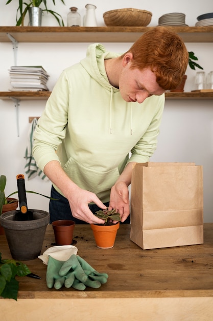 Persona trasplantando plantas en macetas nuevas