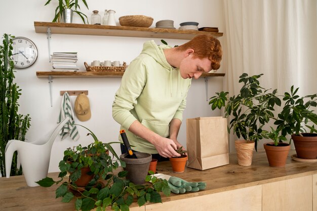 Persona trasplantando plantas en macetas nuevas