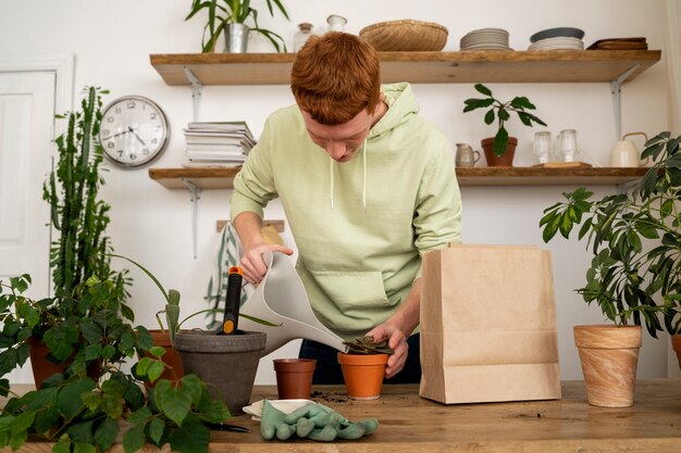 Persona trasplantando plantas en macetas nuevas