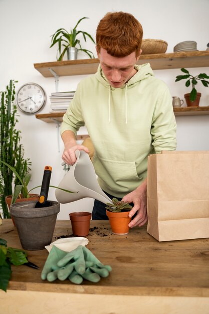 Persona trasplantando plantas en macetas nuevas