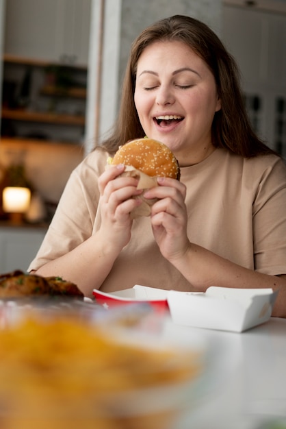 Persona con trastorno alimentario tratando de comer comida rápida.