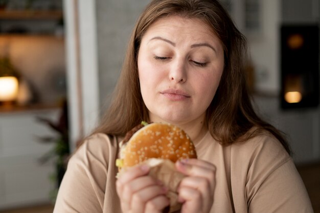 Persona con trastorno alimentario tratando de comer comida rápida.