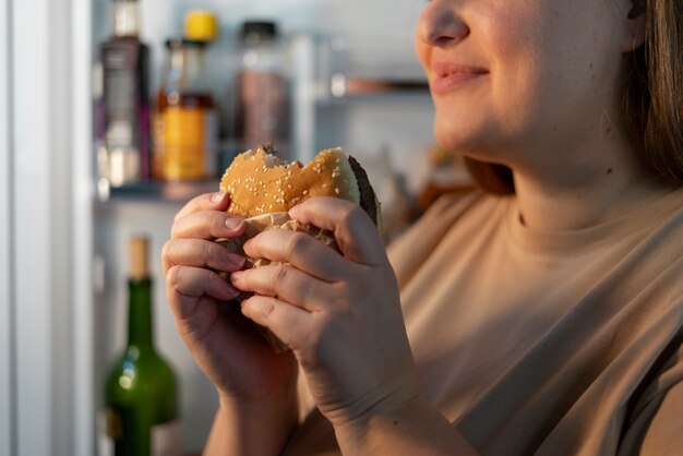 Persona con trastorno alimentario tratando de comer comida rápida.