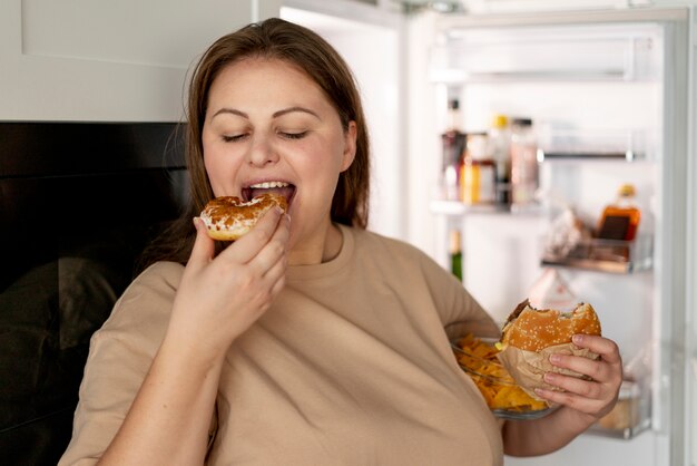 Persona con trastorno alimentario tratando de comer comida rápida.