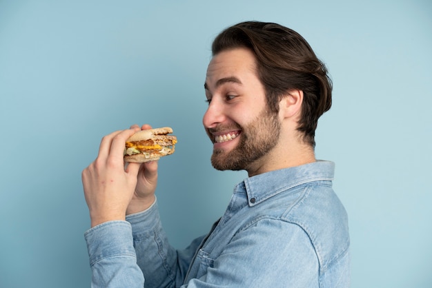 Persona con trastorno alimentario tratando de comer comida rápida.