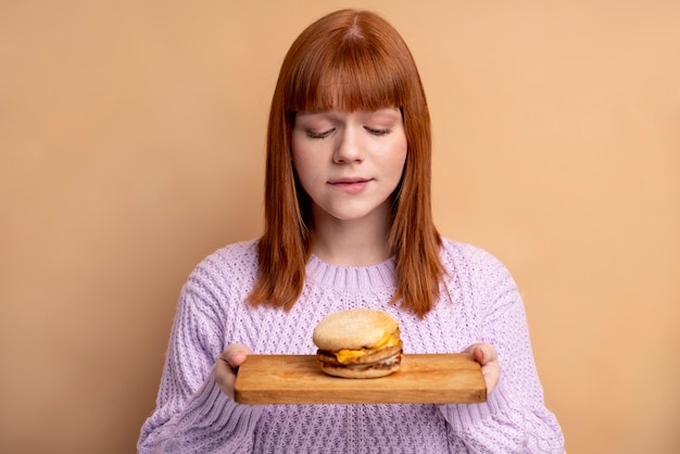 Persona con trastorno alimentario tratando de comer comida rápida.