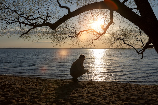 Persona triste y contemplativa cerca del lago.