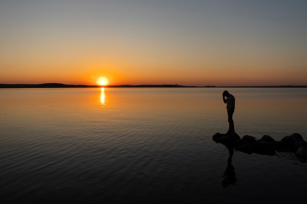 Persona triste y contemplativa cerca del lago.