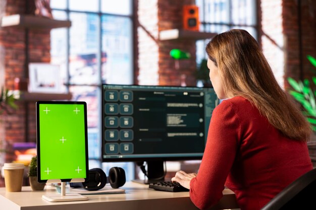 La persona utiliza una herramienta de IA digital en la interfaz web junto a la pantalla verde