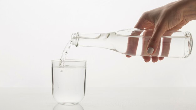 Persona vertiendo agua en vaso