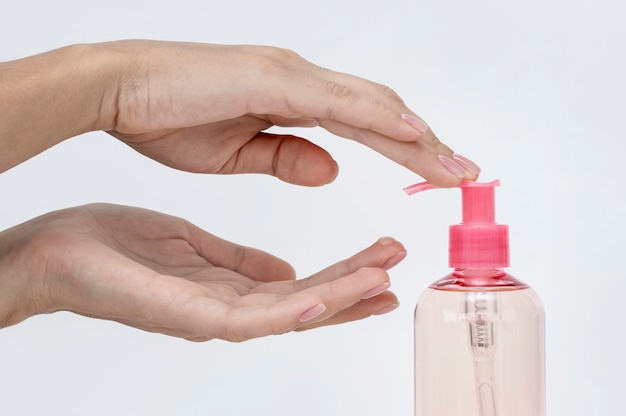 Foto gratuita persona vertiendo jabón líquido de una botella