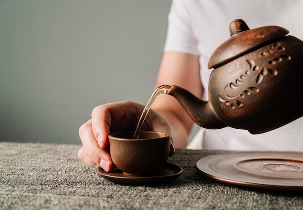 Persona vertiendo té caliente en una taza