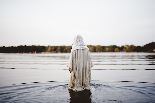 Persona vestida con una túnica bíblica caminando en el agua