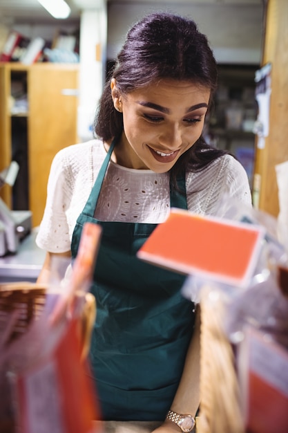 Foto gratuita personal femenino que trabaja en el mostrador de alimentos