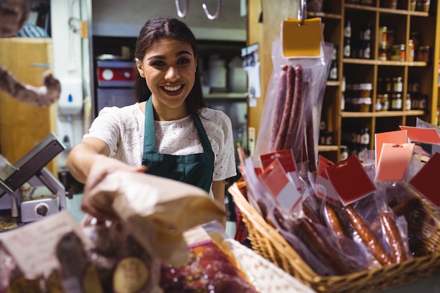 Foto gratuita personal femenino que trabaja en el mostrador de carne