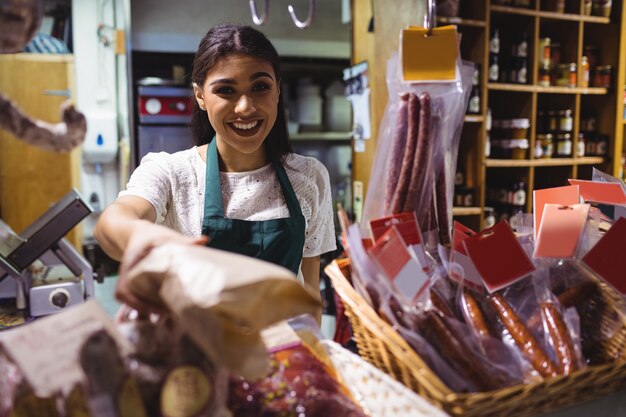 Personal femenino que trabaja en el mostrador de carne