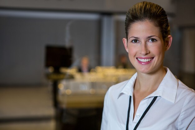 Personal femenino sonriente de pie en el aeropuerto