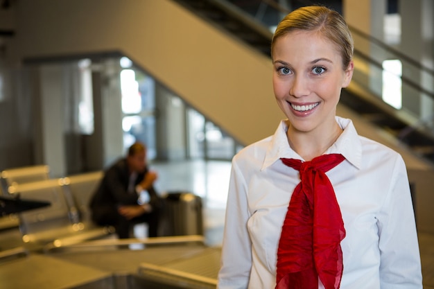 Foto gratuita personal femenino sonriente en la terminal del aeropuerto
