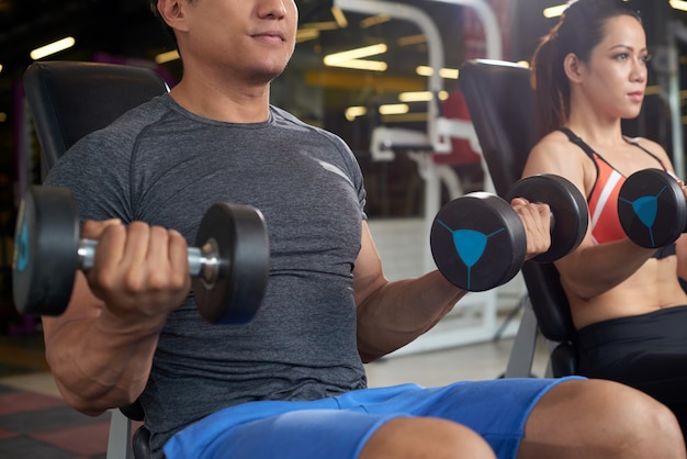 Personas activas haciendo ejercicio de gimnasio levantando pesas