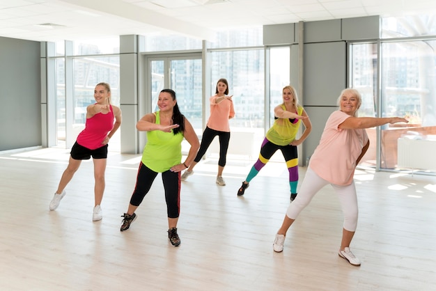 Personas activas que participan juntas en la clase de zumba.