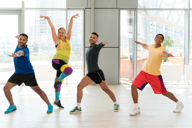 Personas activas que participan juntas en la clase de zumba.