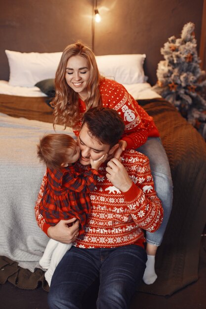 Personas en adornos navideños. Hombre y mujer con un suéter rojo.