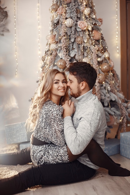 Personas en adornos navideños. Hombre con un suéter gris.