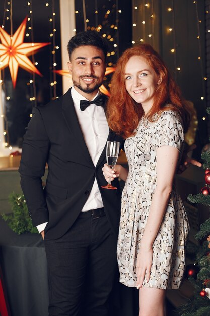 Personas en adornos navideños. Hombre con traje negro.