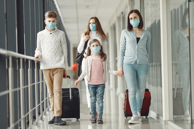 Las personas en el aeropuerto llevan máscaras para protegerse del virus.