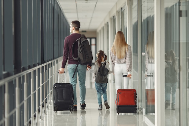 Las personas en el aeropuerto llevan máscaras para protegerse del virus.