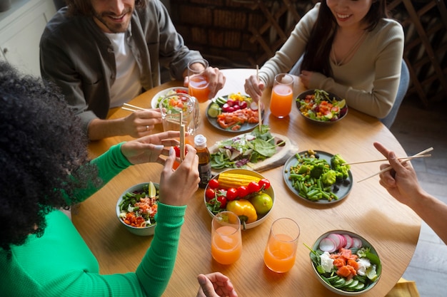 Foto gratuita personas de alto ángulo comiendo tazones de salmón