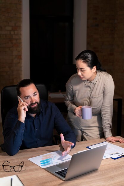 Personas cansadas que trabajan hasta tarde en su oficina.