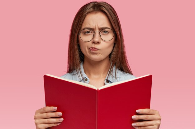 Personas, concepto de educación. Mujer hermosa desconcertada con el pelo largo y oscuro