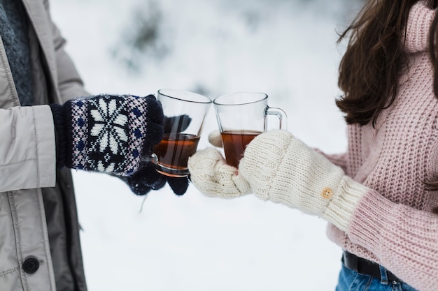 Las personas de cultivos tintinean tazas de té en la naturaleza